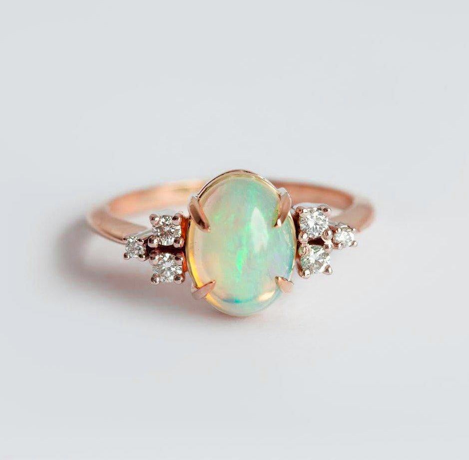 Ovaler Opal-Ehering mit Cabochon-Regenbogen und seitlichen weißen runden Diamanten