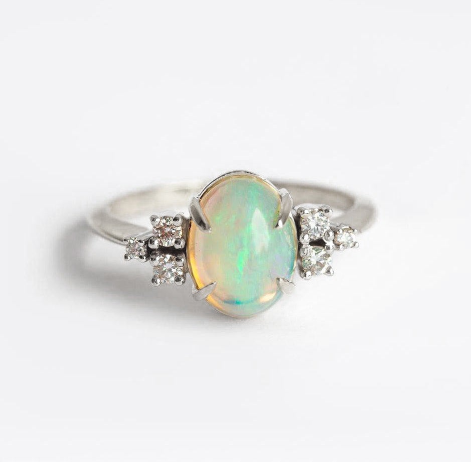 Ovaler Opal-Ehering mit Cabochon-Regenbogen und seitlichen weißen runden Diamanten