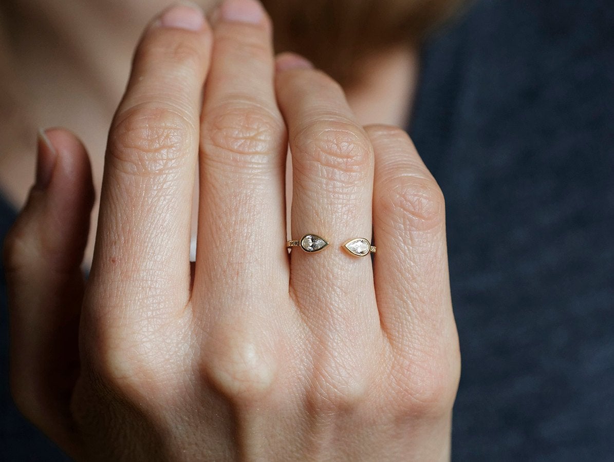 Goldener Hufeisenring mit weißen birnenförmigen Diamanten