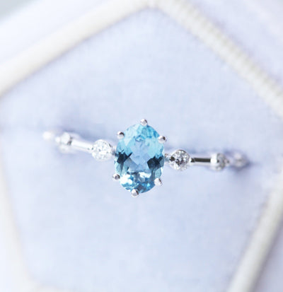 Blauer ovaler Aquamarin-Verlobungsring mit seitlichen weißen Diamanten