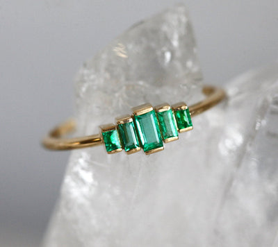 Art-Deco-Smaragd-Baguette-Ring aus 14-karätigem Gold mit Nahaufnahme grüner Edelsteine.