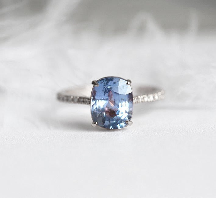 Blauer Saphirring im Kissenschliff mit Diamanten