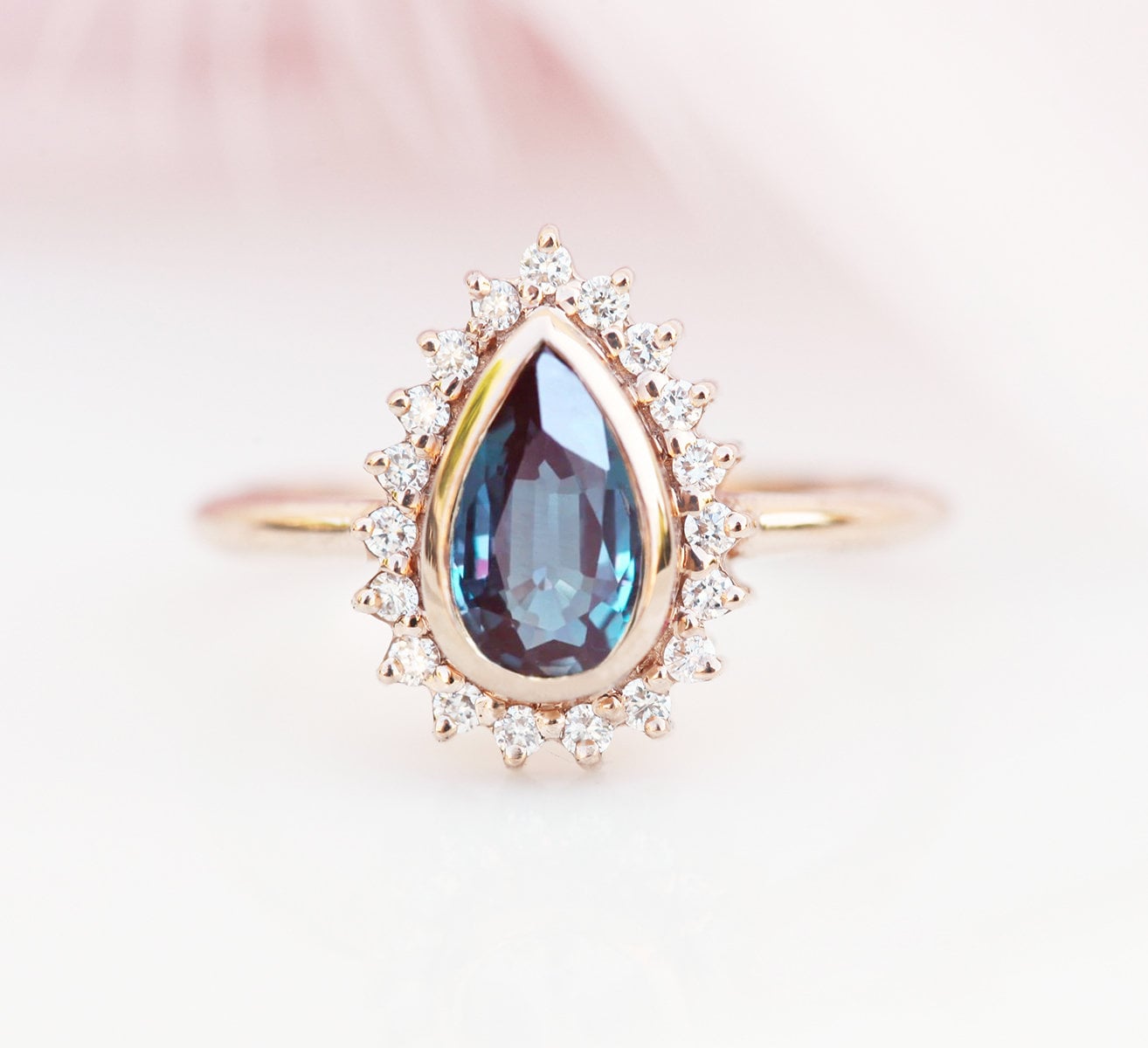 Blauer Birnen-Alexandrit-Ring mit vielen kleineren weißen Diamanten an der Seite