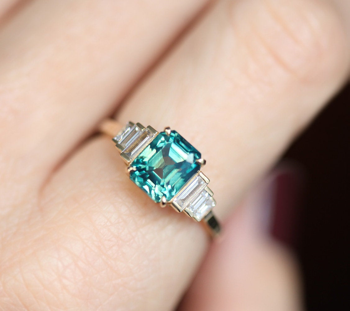 Art-déco-Ring mit blauem Saphir im Strahlenschliff und weißen Diamanten in Baguetteform