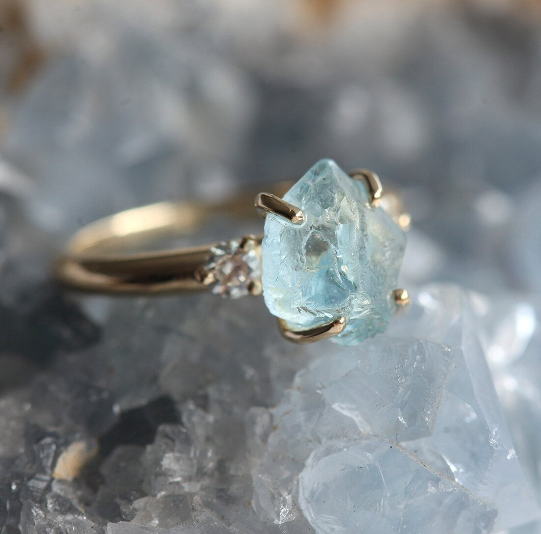 Ring aus drei Steinen im Rohschliff mit Aquamarin und zwei runden weißen Diamanten