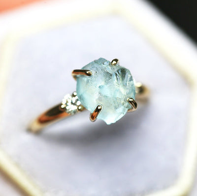 Ring aus drei Steinen im Rohschliff mit Aquamarin und zwei runden weißen Diamanten