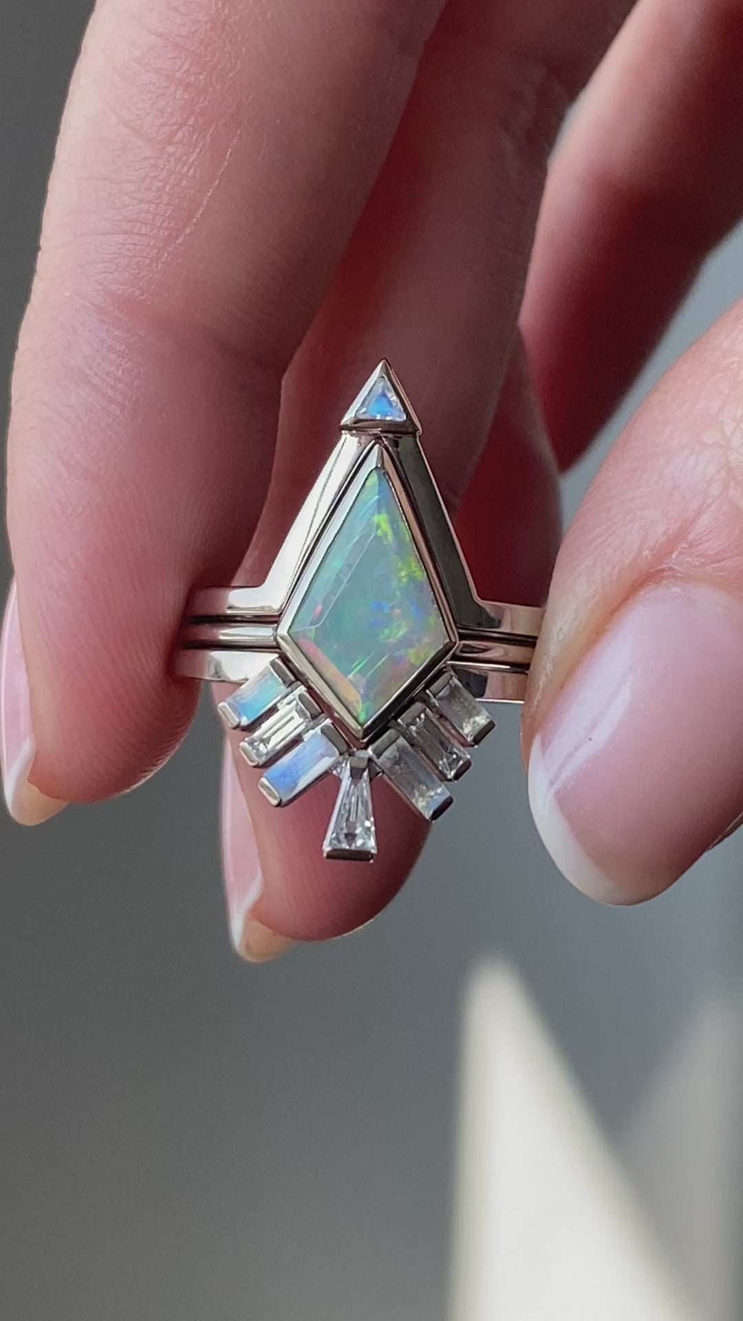 Weißer Kite-Opal-Ring, besetzt mit Baguette-Mondsteinen und spitz zulaufenden Baguette-Diamanten. Videoübersicht